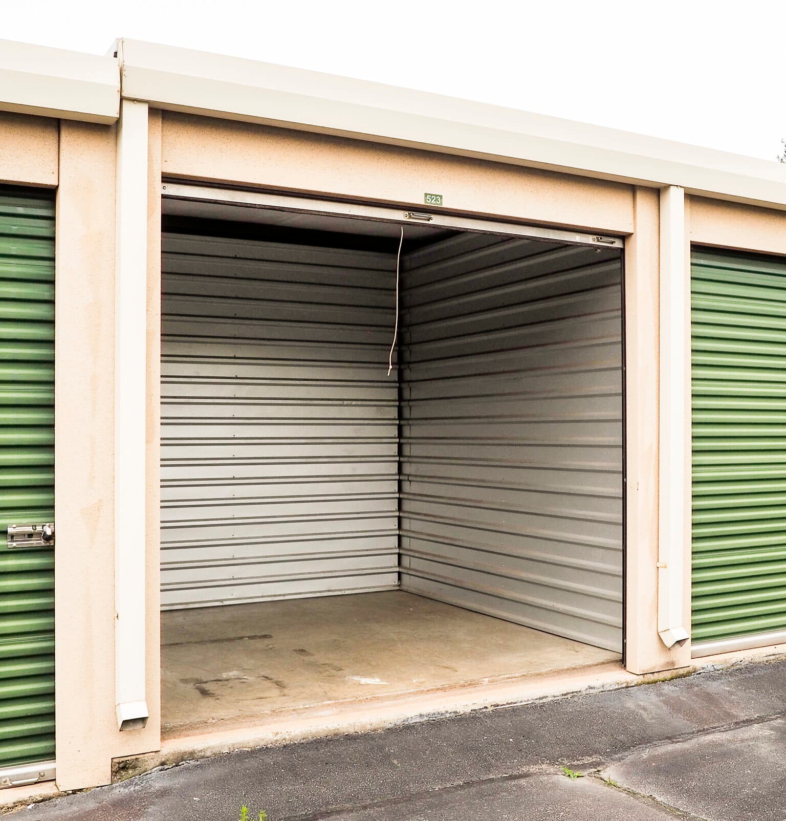 Open, empty drive-up storage unit with a roll-up door